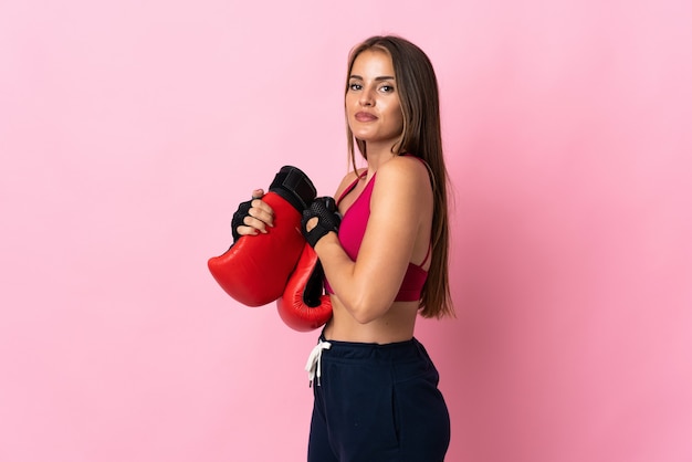 Jeune femme uruguayenne isolée sur mur rose avec des gants de boxe