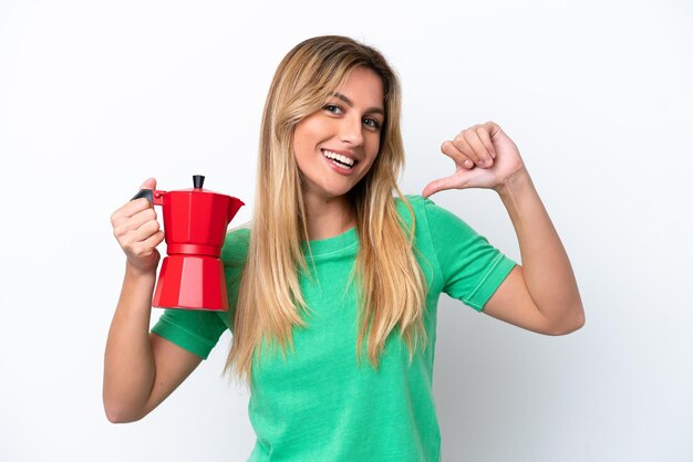 Jeune femme uruguayenne tenant une cafetière isolée sur fond blanc fière et satisfaite