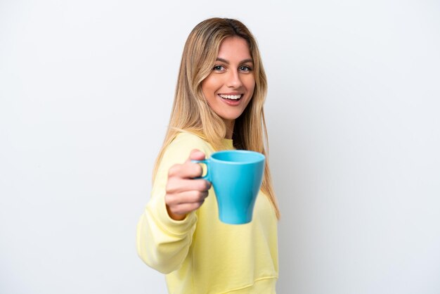 Jeune femme uruguayenne tenant une tasse de café isolé sur fond blanc avec une expression heureuse