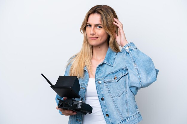 Photo jeune femme uruguayenne tenant une télécommande de drone isolé sur fond blanc ayant des doutes