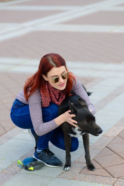 Jeune femme utilisant un masque facial comme prévention de propagation du coronavirus marchant avec son chien. Image conceptuelle de la pandémie mondiale de COVID-19.