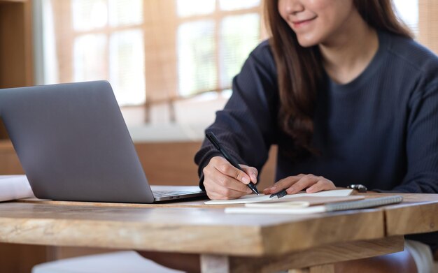 Une jeune femme utilisant un ordinateur portable pour travailler ou étudier en ligne à la maison