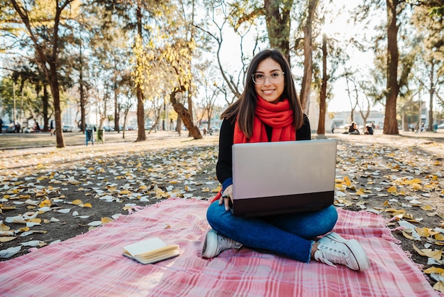 jeune femme utilisant un ordinateur portable pour travailler à l'extérieur
