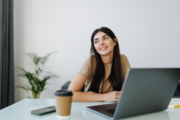 Jeune femme utilisant un ordinateur portable et travaillant à domicile