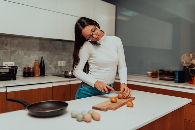 Une jeune femme utilisant un smartphone pendant la cuisson dans la cuisine