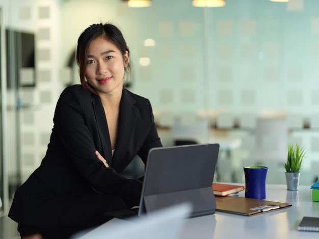 Jeune femme utilisant le téléphone assise sur la table