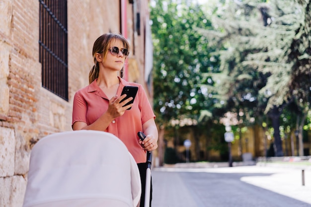 Une jeune femme utilisant un téléphone portable alors qu'elle est assise à l'extérieur