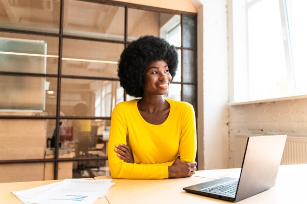 Photo une jeune femme utilisant un téléphone portable alors qu'elle est assise sur la table.