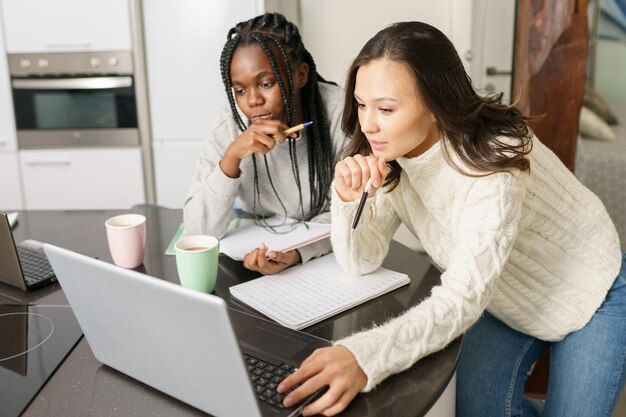 Photo une jeune femme utilisant un téléphone portable alors qu'elle est assise sur la table.