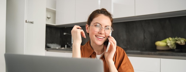 Photo une jeune femme utilisant un téléphone portable assise sur le canapé à la maison