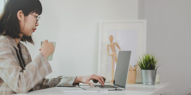 Une jeune femme utilisant un téléphone portable assise sur une table