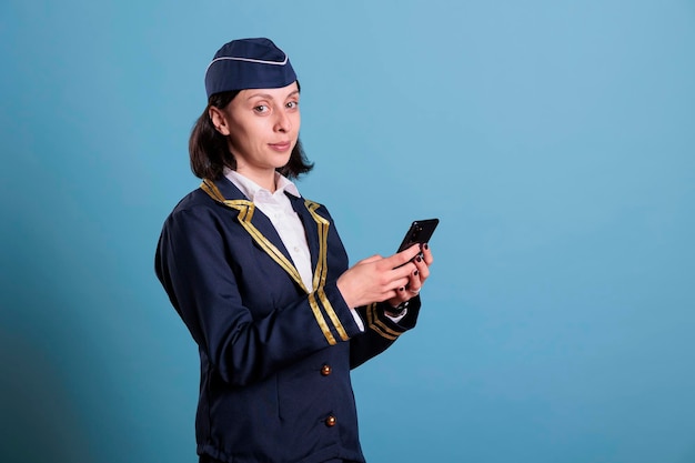 Une jeune femme utilisant un téléphone portable sur un fond bleu