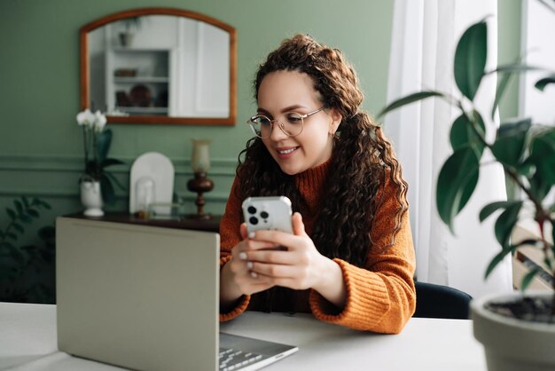 Jeune femme utilisant un téléphone portable à la maison