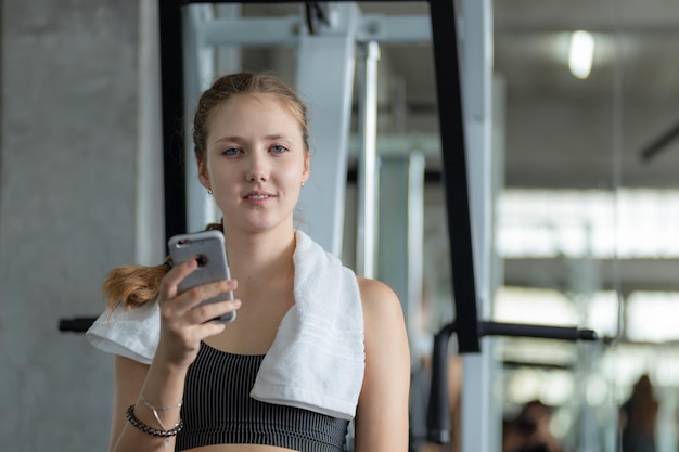 Jeune femme utilisant un téléphone portable en salle de sport