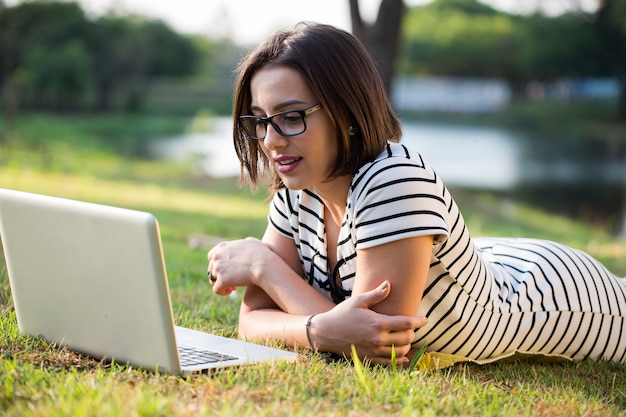 Jeune femme, utilisation, ordinateur portable, dans parc