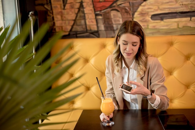 Jeune, femme, utilisation, téléphone portable, café