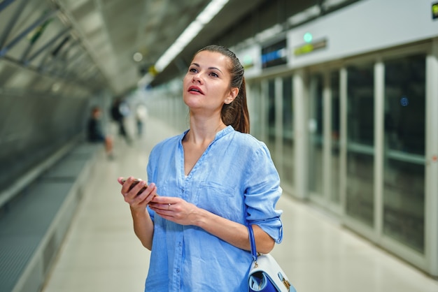 Jeune femme, utilisation, téléphone portable, dans, station métro