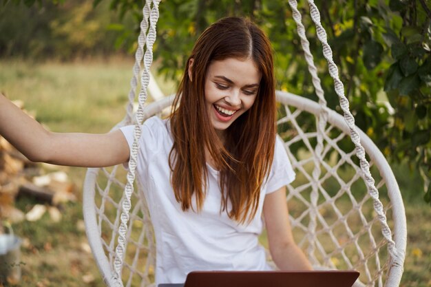 Photo une jeune femme utilise un ordinateur portable dans le parc.