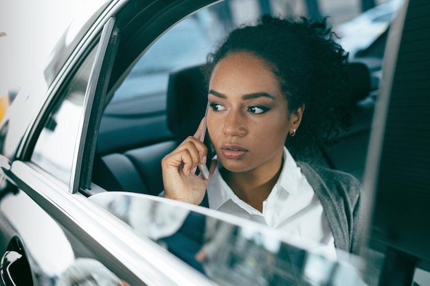 Une jeune femme utilise un smartphone dans la voiture.