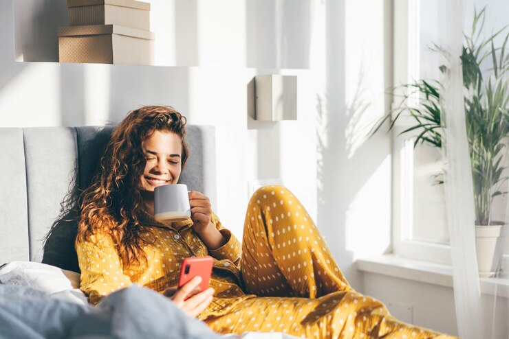 Photo une jeune femme utilise son téléphone alors qu'elle est assise sur le canapé à la maison.