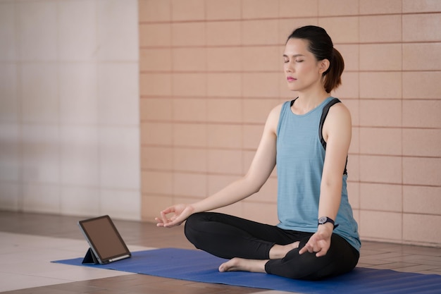 Une jeune femme utilise son téléphone alors qu'elle est assise par terre.