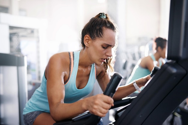 Une jeune femme utilise un téléphone portable alors qu'elle est assise au gymnase.