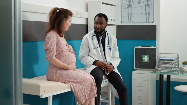 Photo une jeune femme utilise un téléphone portable alors qu'elle se tient dans une clinique.