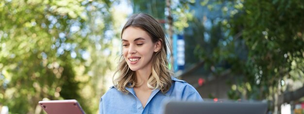 Photo une jeune femme utilise un téléphone portable alors qu'elle se tient à l'extérieur