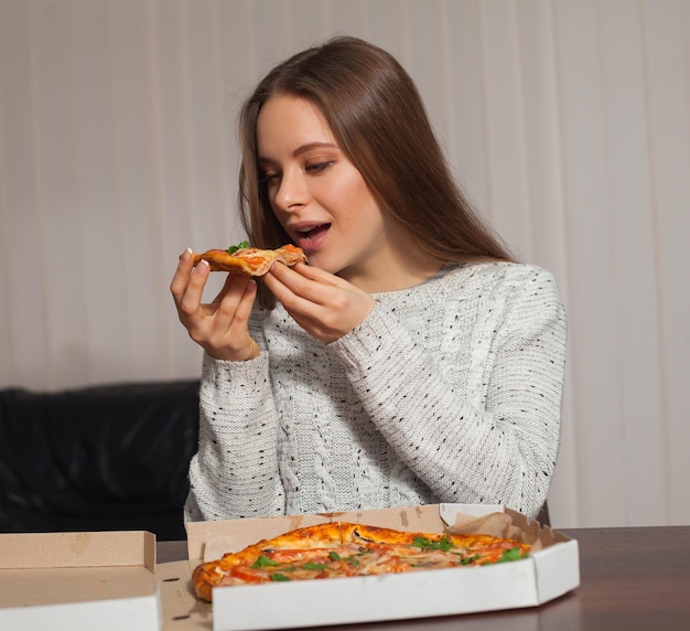 La jeune femme va goûter la pizza