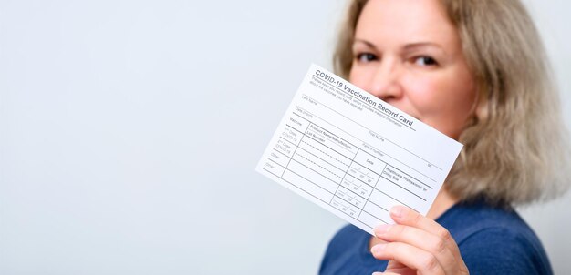 Photo jeune femme vaccinée montrant la carte de vaccination covid19