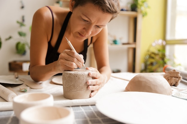 Jeune femme de la vaisselle en céramique et poterie à l'atelier