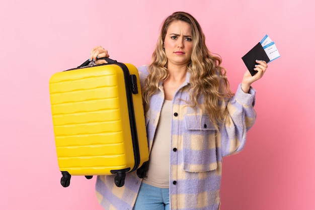 Jeune femme avec valise de voyage jaune