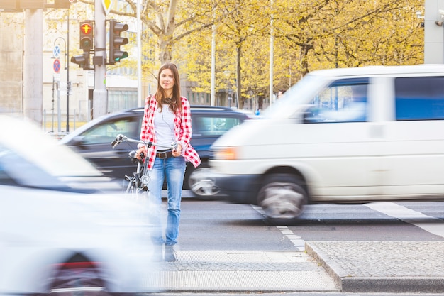 Jeune femme à vélo attendant de traverser la rue