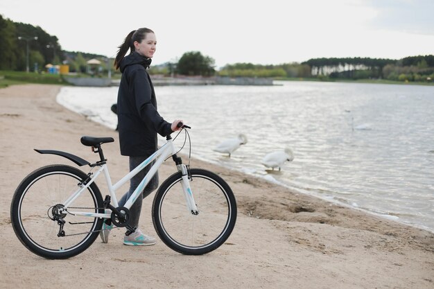 Une jeune femme avec un vélo sur le lac