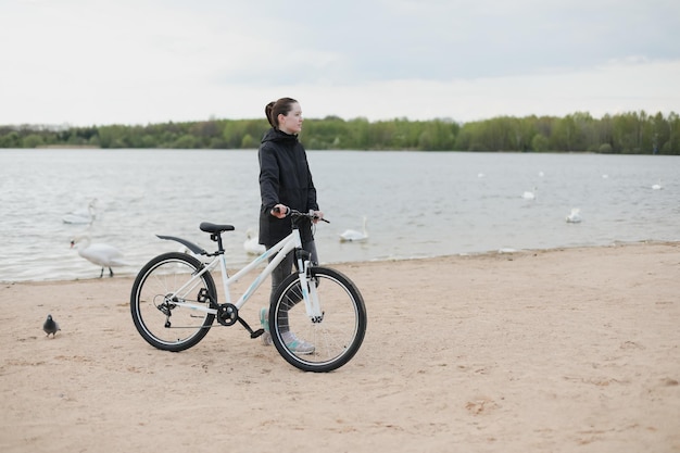 Une jeune femme avec un vélo sur le lac