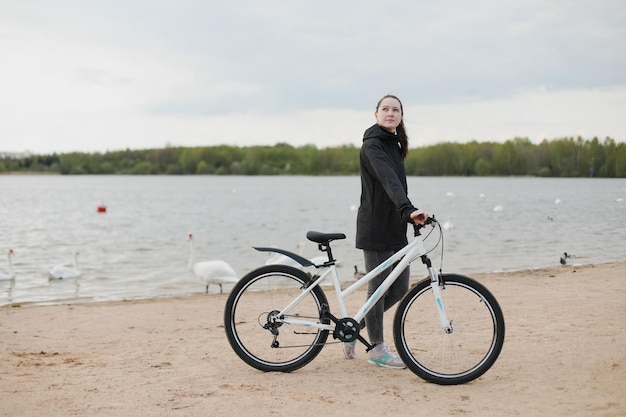 Une jeune femme avec un vélo sur le lac