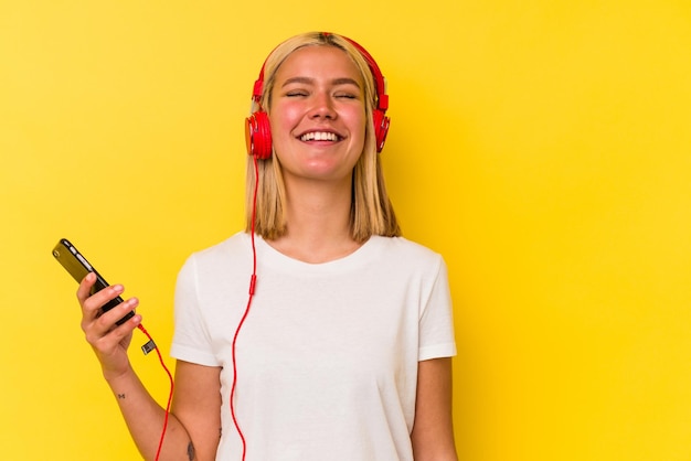 Jeune femme vénézuélienne écoute de la musique isolée sur fond jaune