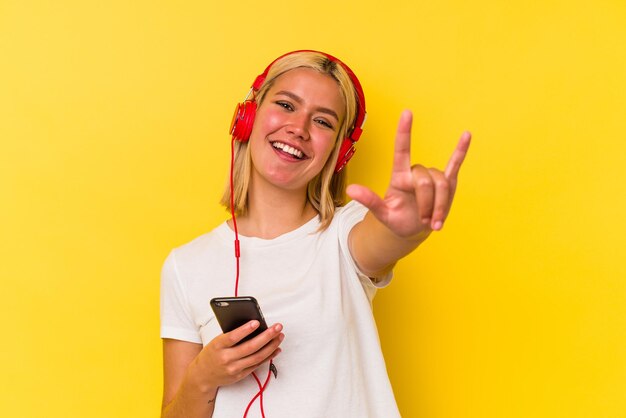 Jeune femme vénézuélienne écoute de la musique isolée sur fond jaune