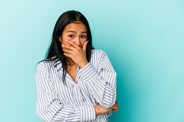 Jeune femme vénézuélienne isolée sur fond bleu effrayée et effrayée.