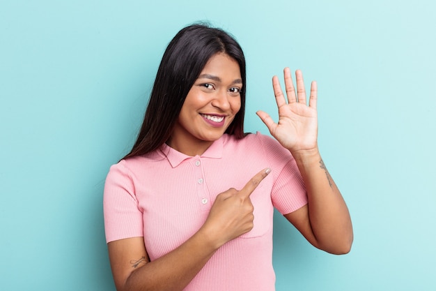 Jeune femme vénézuélienne isolée sur fond bleu souriant joyeux montrant le numéro cinq avec les doigts.