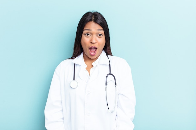 Jeune femme vénézuélienne médecin isolée sur fond bleu criant très en colère et agressive.