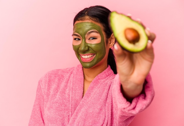 Jeune femme vénézuélienne portant un masque facial isolé sur fond rose