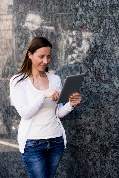 Photo jeune femme vérifiant le courrier sur sa tablette à l'extérieur