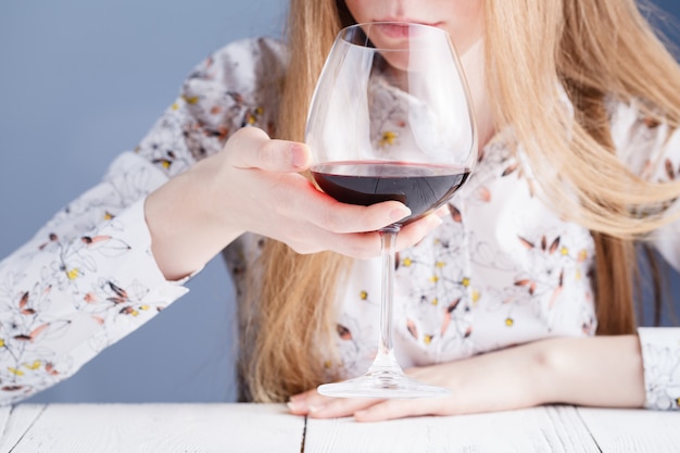 Jeune femme avec un verre de vin. Accro à la drogue et à l'alcool.