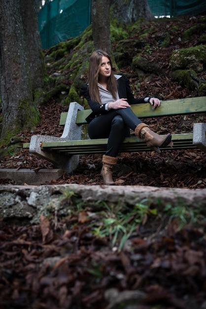 jeune femme en veste assise sur le banc