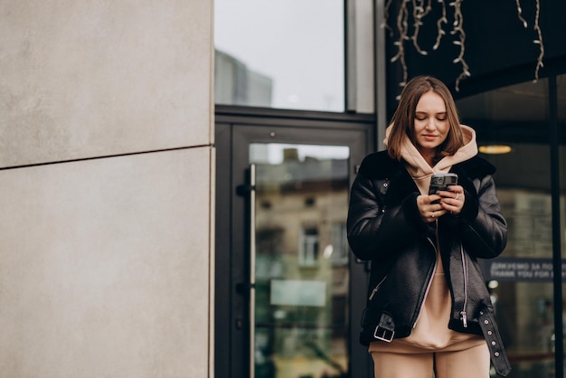 Jeune femme en veste marchant dans la rue