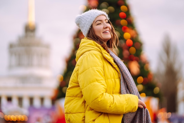 Jeune femme en vêtements d'hiver chauds posant au festival Vacances d'hiver