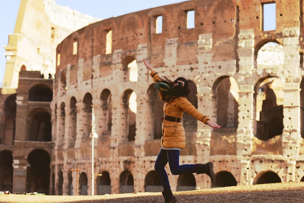 Jeune femme en vêtements d'hiver s'amuser dans le Colisée à Rome