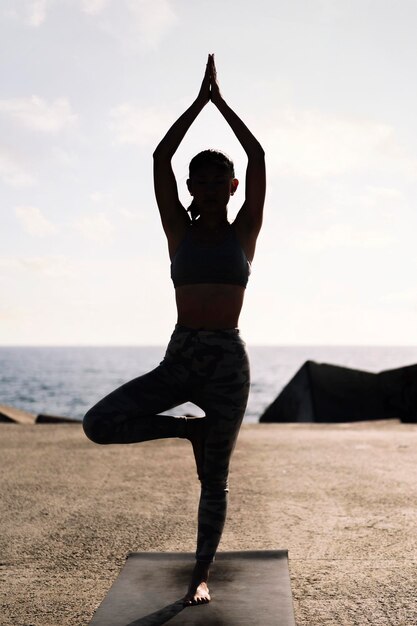 Une jeune femme en vêtements de sport en position de yoga