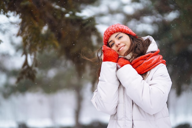 Jeune femme en vêtements de style hiver sur fond de forêt enneigée Vacances nature